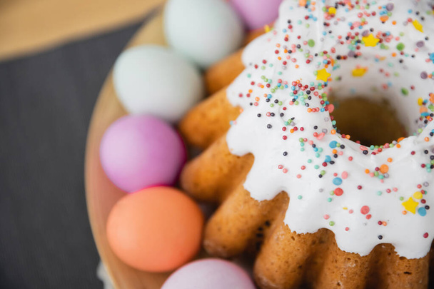 Top view of sweet Easter cake and colorful eggs on table  - Foto, imagen