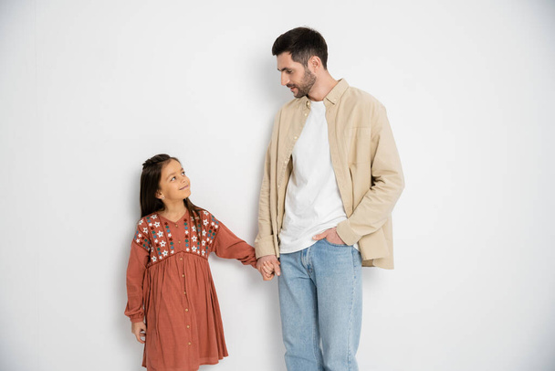 Father and daughter holding hands on white background  - Foto, immagini