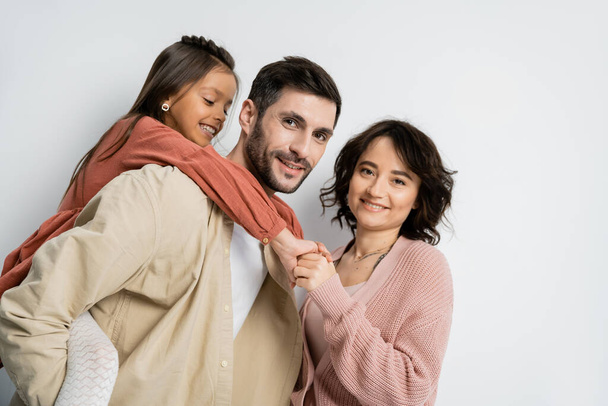 Portrait of positive family looking at camera on white background  - Foto, Imagen