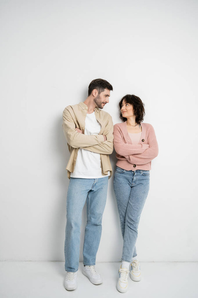 Couple brune croisant les bras debout sur fond blanc  - Photo, image