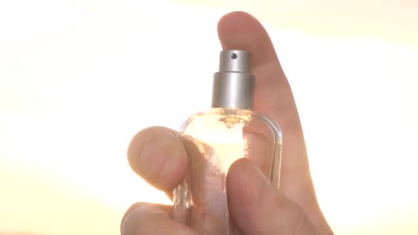 Spritzer Parfüm auf dem Hintergrund des Sonnenuntergangs. Parfümwerbung. 4k-Video - Filmmaterial, Video