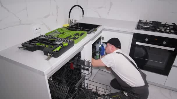 Вид зверху майстра, який встановлює меблі та техніку в кухонній кімнаті. Встановлення посудомийної машини. 4k відео
 - Кадри, відео
