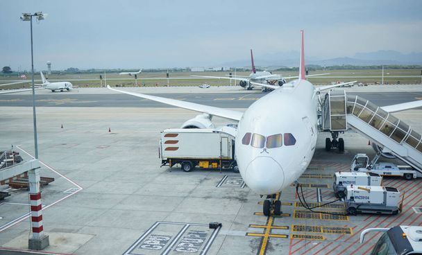 Airplane, airport or loading luggage for traveling outdoors on runway at worldwide location for journey. Trip, transportation services or commercial aeroplane on ground for international flight cargo. - Foto, Imagem