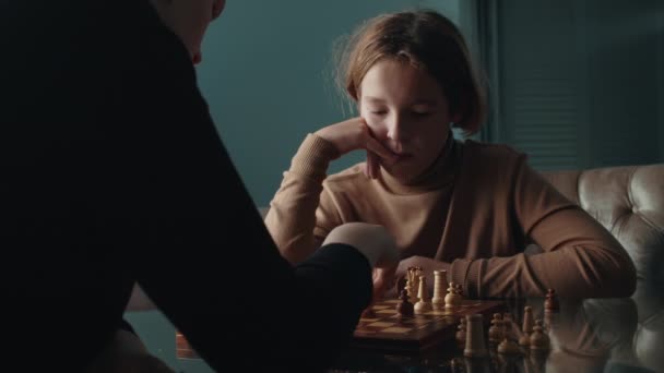 Middle shot of son and his mother connecting through a game of chess. Woman thinks and then makes a move - Video