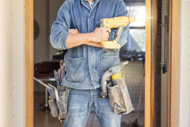 Man, DIY and drill for construction, building or home repair, renovation and improvement. Equipment, handyman and male ready for maintenance, architecture or house design project as a professional. - Photo, Image