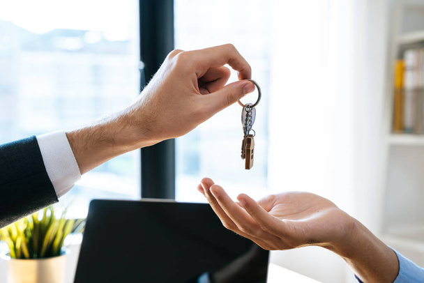 Риэлтор дарит ключи от дома покупателю-арендатору. - Фото, изображение