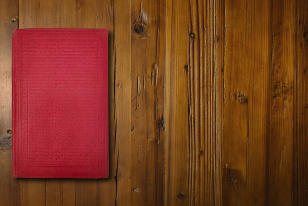 茶色の木製の机の上の赤い本のクローズアップ. - 写真・画像
