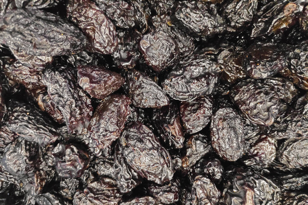 Close-up on a stack of organic dried plums for sale in a market stall. - Fotoğraf, Görsel