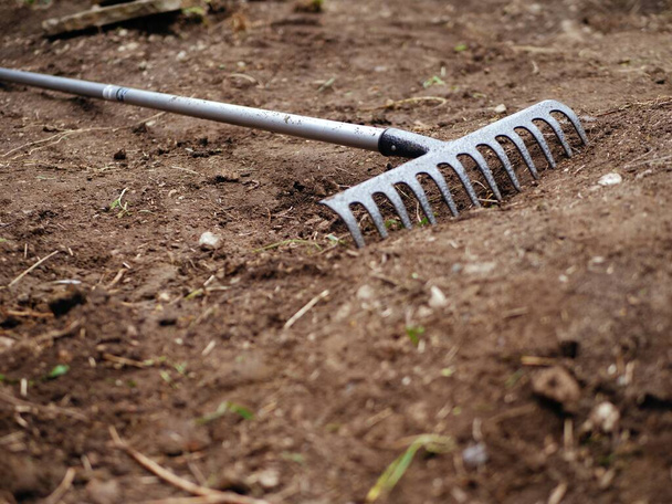 Garden rake on fresh soil in the garden wide shot selective focus - Photo, Image
