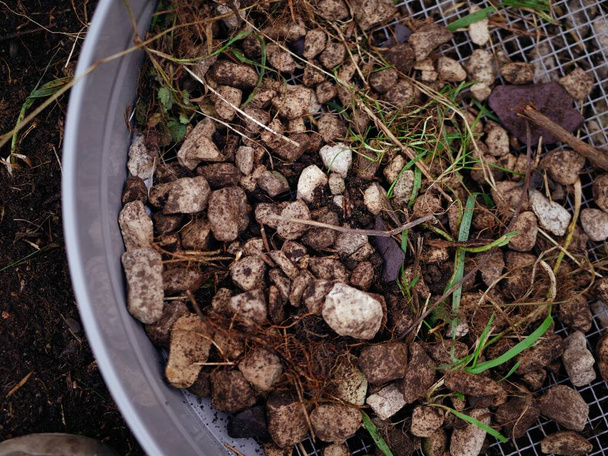 Почва и камни в решето почвы для просеивания крупным планом селективного фокуса - Фото, изображение