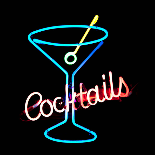 Close-up on a neon light shaped into a martini glass with written across it "Cocktails". - Zdjęcie, obraz