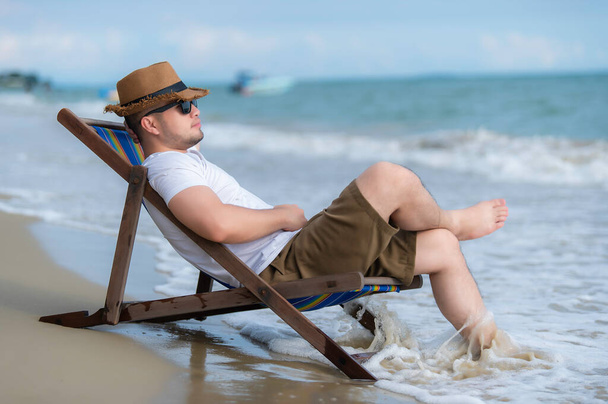 Asian man sitting chair beach inside sea,Relax time at summer - Zdjęcie, obraz