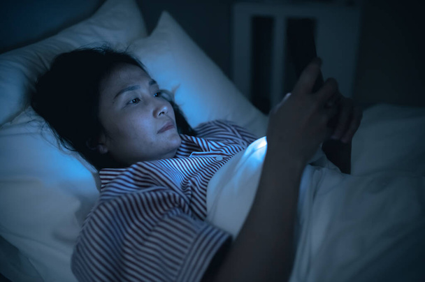 Asian woman playing game on smartphone in the bed at night,Thailand people,Addict social media - Fotografie, Obrázek