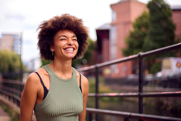 Smiling Young Woman Outdoors Laughing As She Walks Through City - Foto, Bild