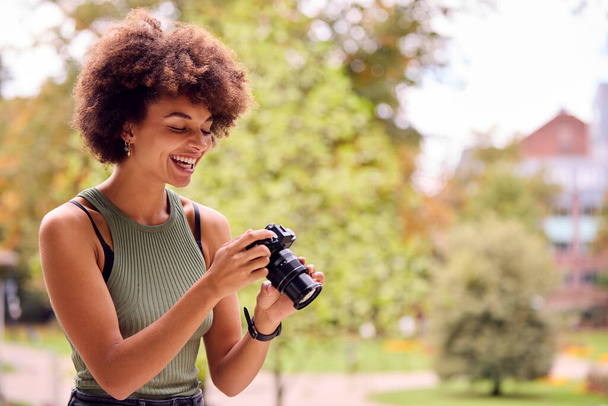 Young Woman Outdoors With DSLR Camera Taking Photos In City Park - Foto, Bild