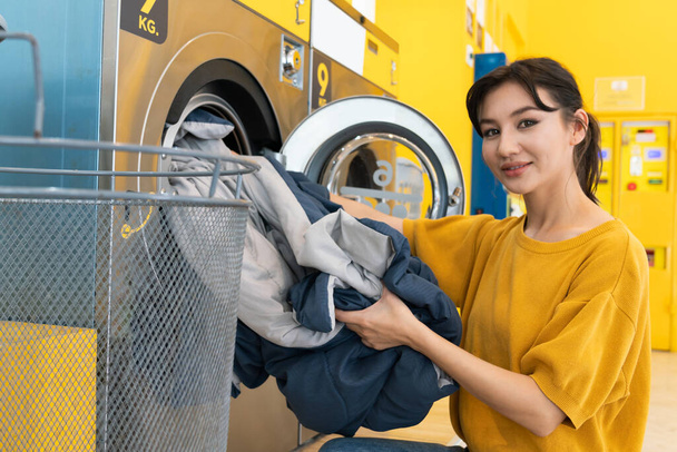 Asian people using qualified coin operated laundry machine in the public room to wash their cloths. Concept of a self service commercial laundry and drying machine in a public room. - Фото, зображення