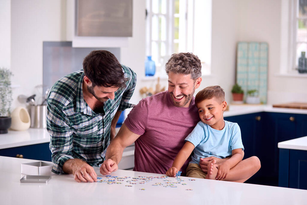 Same Sex Family With Two Dads And Son Doing Jigsaw Puzzle In Kitchen At Home - Fotoğraf, Görsel