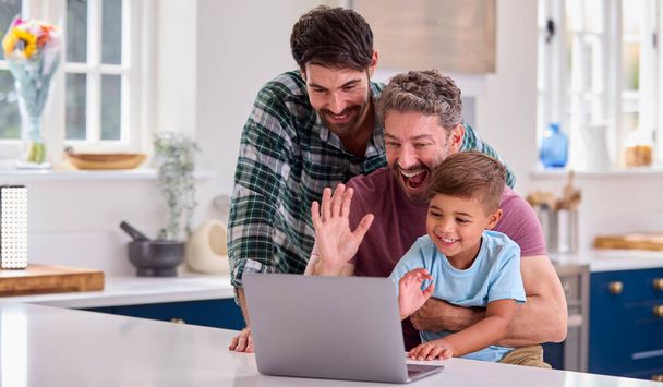Same Sex Family With Two Dads And Son At Home In Kitchen Making Video Call On Laptop - Foto, immagini