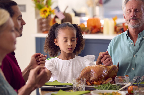 Multi-Generation Family Celebrating Thanksgiving At Home Saying Prayer Before Eating Meal Together - Fotó, kép