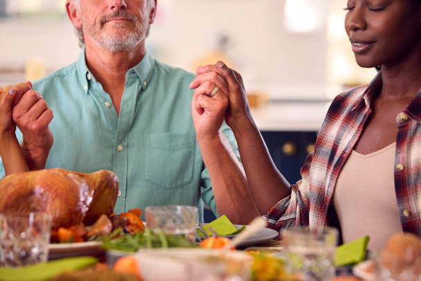 Multi-Generation Family Celebrating Thanksgiving At Home Saying Prayer Before Eating Meal Together - Valokuva, kuva