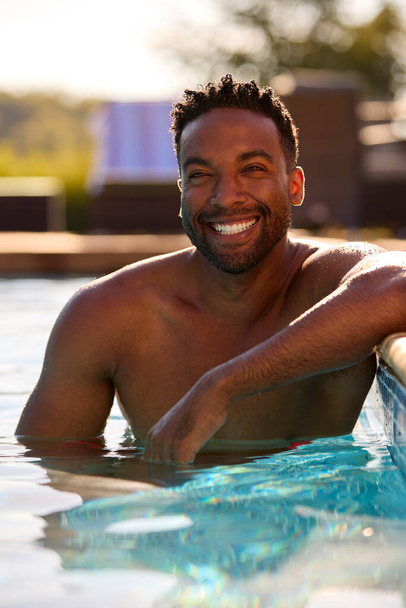 Portrait Of Smiling Man On Summer Holiday Relaxing In Swimming Pool - Foto, Bild