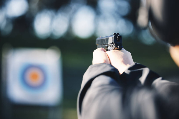 Gun, target and person training outdoor for shooting range, game exercise or sports event closeup. Hands with firearm and circle for aim, vision and practice, police learning academy or field gaming. - Photo, Image