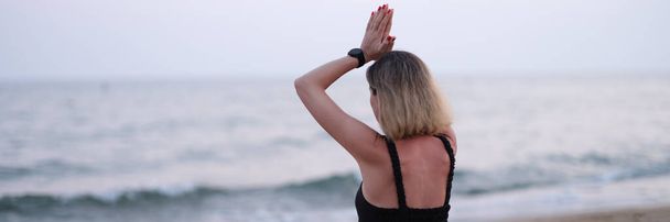 Медитирующая женщина-йога сидит на берегу моря. Расслабляющая медитация на пляже - Фото, изображение