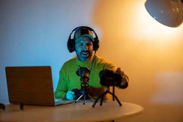 muž středního věku vlogger pro hráče streaming se svými předplatiteli. Nahrával živé vysílání videoher v noci doma. kyber sporty - Fotografie, Obrázek