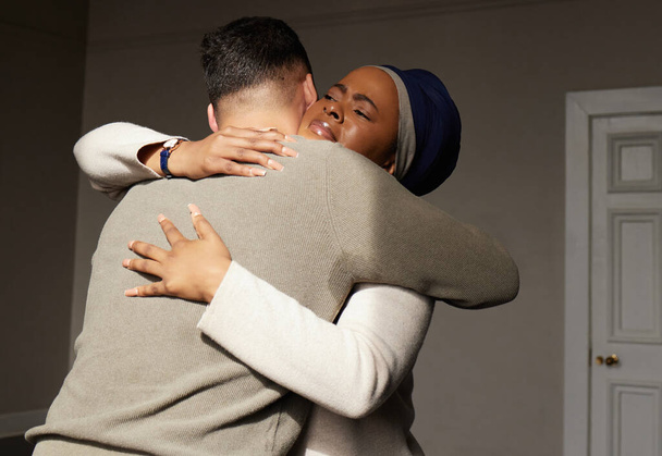 Hug, support and woman embrace a man for comfort, grief and care after bad news or problems in a home or house. Cancer, sad and depression by people hugging for empathy, love and hope together. - Foto, Bild