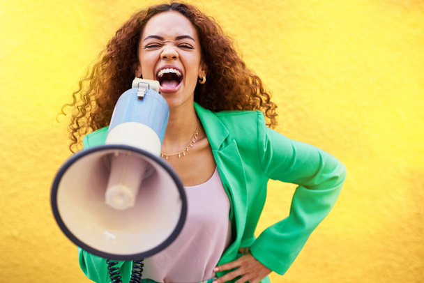 Woman, megaphone and protest on yellow background of speech, announcement and screaming noise. Female broadcast voice for human rights, justice and news for attention, opinion and gen z speaker sound. - Photo, Image