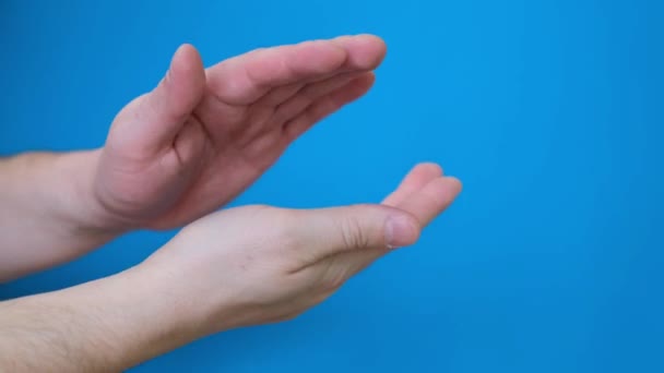 Close-up van mannelijke handen klapperend tegen een blauwe scherm achtergrond. Chromakey. 4k video - Video