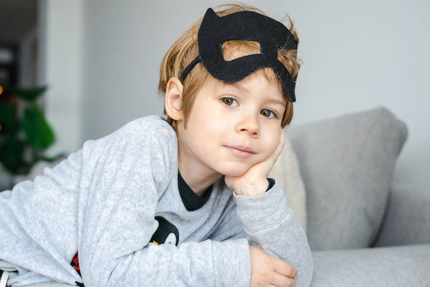 Little Boy with carnival costume . Costume of bat lying on sofa. - Foto, imagen