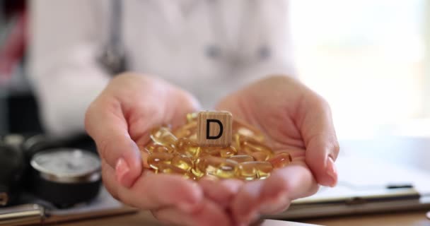 Ruokavalioterapeutti kädet tilalla monia D-vitamiinia kapseleita. D-vitamiinianalyysi ja päivittäinen saanti - Materiaali, video
