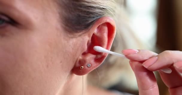 Zbliżenie kobiety czyszczącej uszy i używającej końcówki Q. Koncepcja higieny osobistej i pielęgnacji ucha - Materiał filmowy, wideo