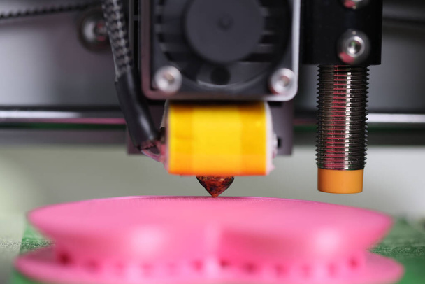 Detalhe de close-up da impressora 3D e um modelo rosa de um modelo tridimensional. Equipamento de trabalho - Foto, Imagem