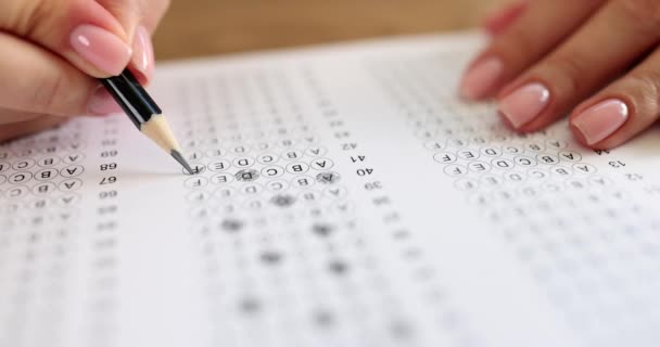 Mulher mão segura lápis e marca respostas para testar no exame. Escolha da resposta no teste - Filmagem, Vídeo