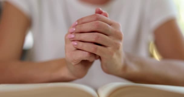 Vrouwelijke handen die bijbel lezen en bidden in de aanbidkamer in de christelijke kerk. Geloof hoop en gebed concept - Video