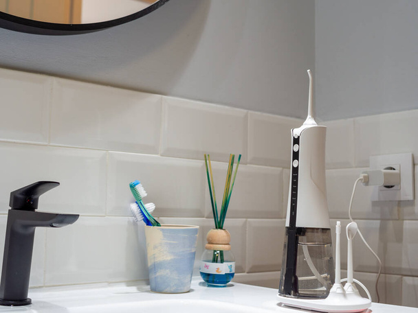 domestic dental water flosser on the bathroom wash basin - Foto, afbeelding