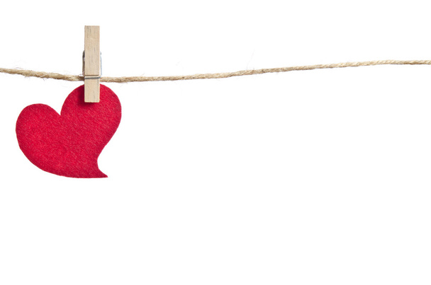 Red fabric hearts hanging on the clothesline . On white backgrou - Фото, изображение