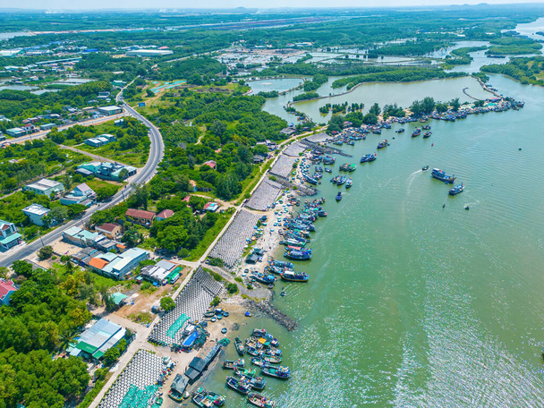 Beautiful blue skyline panoramic in Loc An Canal. Scenery landscape of fishing port with tsunami protection concrete blocks. Cityscape and boats in the sea. Loc An village near Vung Tau City. - 写真・画像