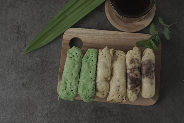 Kue Pukis είναι παραδοσιακά ινδονησιακά κέικ. Φτιαγμένα με ένα απλό μείγμα από αυγά, ζάχαρη και αλεύρι, αυτά τα στρογγυλά κεράσματα είναι μια γλυκιά προσθήκη σε κάθε ώρα σνακ. Απολαύστε με ένα φλιτζάνι τσάι ή καφέ. - Φωτογραφία, εικόνα