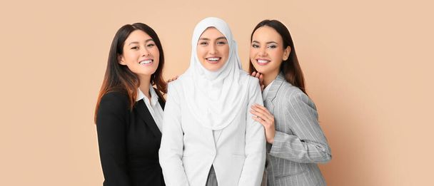 Beautiful businesswomen on beige background. Unity concept - Foto, Bild