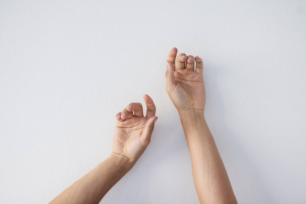 Revel in your skin. a unrecognizable persons hands against a grey background stretching up - Foto, afbeelding