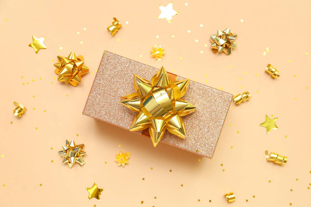 Gift box with golden bows and stars on beige background - Fotografie, Obrázek