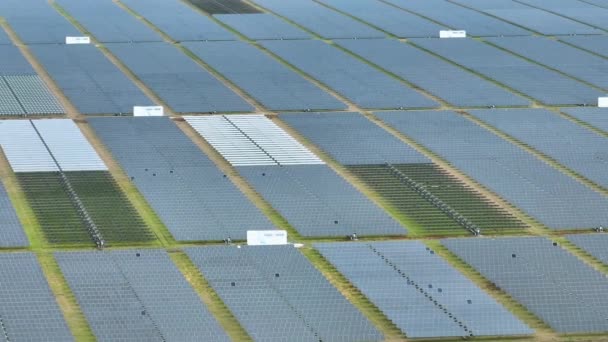 Luchtfoto van een grote duurzame elektriciteitscentrale met vele rijen fotovoltaïsche zonnepanelen voor de productie van schone elektrische energie. Hernieuwbare elektriciteit zonder uitstoot. - Video