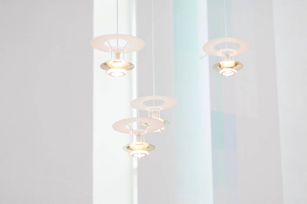 Moderní a futuristické stropní lampy s jednoduchým kruhovým designem. Bílé přívěskové lampy s pěknými detaily na bílém pozadí. Čerstvý a čistý pocit ve skandinávském domě. - Fotografie, Obrázek