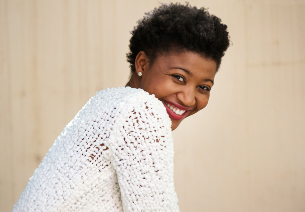 Χαρούμενος νεαρός μαύρη γυναίκα που χαμογελά στο λευκό πουλόβερ - Φωτογραφία, εικόνα