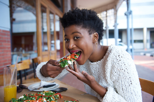 Joven afroamericana mujer comiendo pizza
 - Foto, imagen