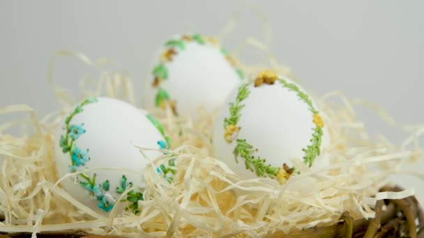 Великдень три красиві вишиті яйця зі стрічками яєчної шкаралупи в гнізді з обгорткою паперового білого фону простір для тексту привітання зустріч з сімейним прикрасою додому прикраса подарунків
 - Кадри, відео