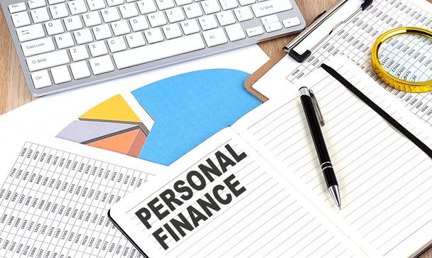 PERSONAL FINANCE text on a notebook with chart and keyboard - Valokuva, kuva